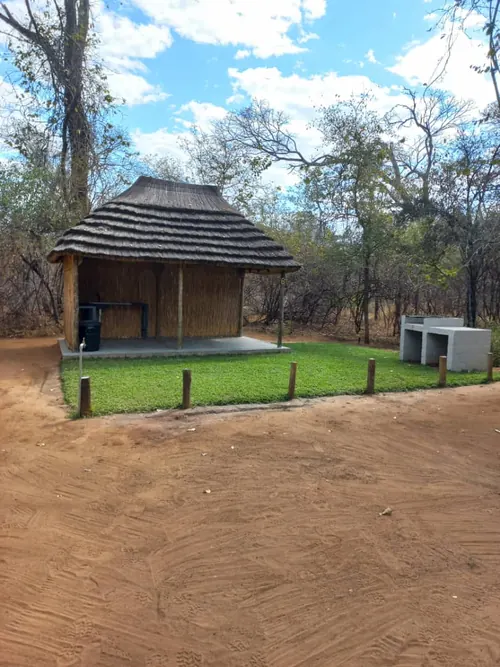 Campsite 6 with a thatched shelter and lawn