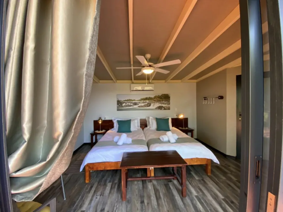 Chalet bedroom with twin beds, ceiling fan and sliding doors